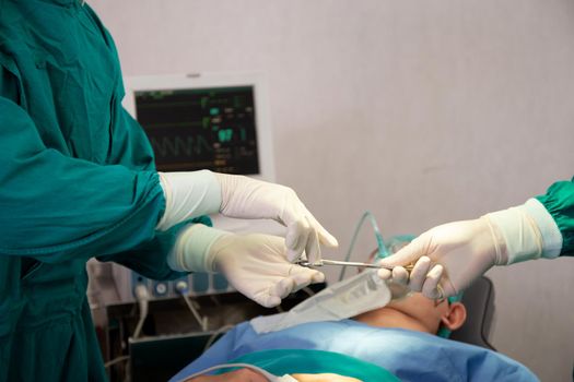 Closeup hands of doctor sending instrument with surgeon with rescue and  save patient in the operation room at hospital, surgery and emergency, medical and technology, specialist and assistant.