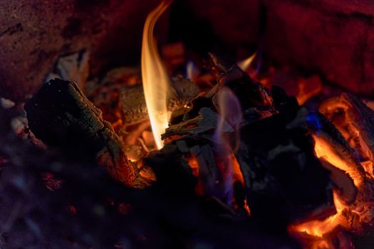 Burning black coals and fire bred in the fireplace. Close up