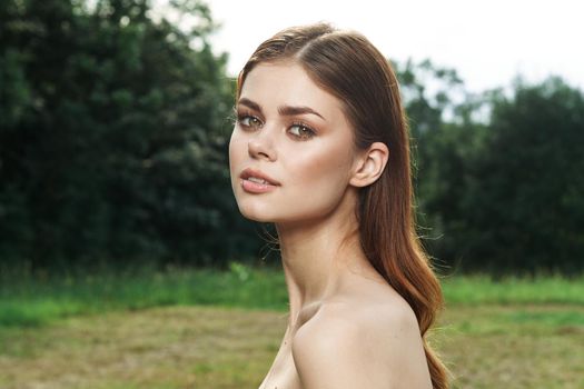 smiling woman in a field outdoors bare shoulders clear skin model. High quality photo