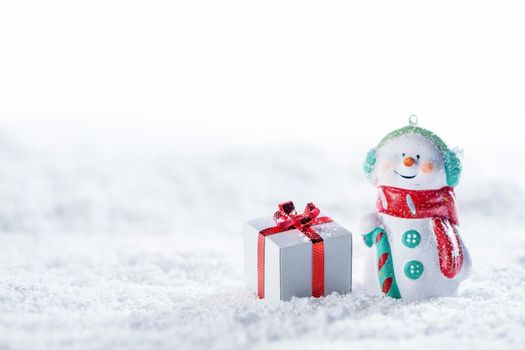 Christmas and New Year snowman and gift on a white snow background