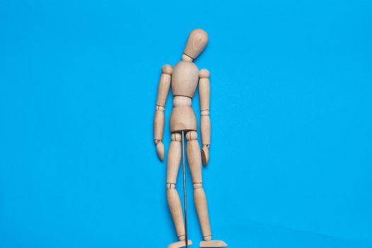 wooden man mannequin blue background design object. High quality photo