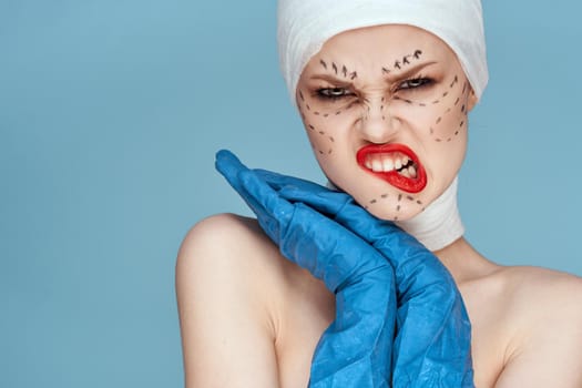 female patient posing in blue gloves red lips surgery facial rejuvenation studio lifestyle. High quality photo
