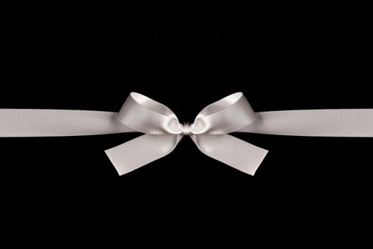 White ribbon bow on black background, black friday holiday gift