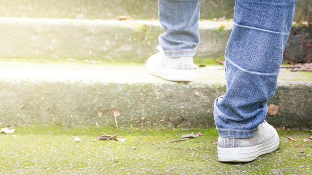 Feet Sneakers And Jeans Walking On Staircase Outdoor With Autumn Season Nature On Background Lifestyle Fashion Trendy Style, Walking In The Park Outdoors.