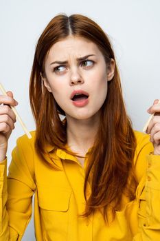 woman eating sushi with japanese chopsticks posing light background. High quality photo