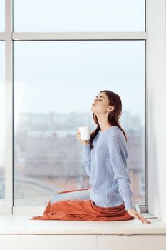 woman near the window dreamy look rest at home comfort. High quality photo