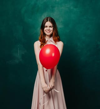 pretty woman in dress red balloon holiday green background. High quality photo