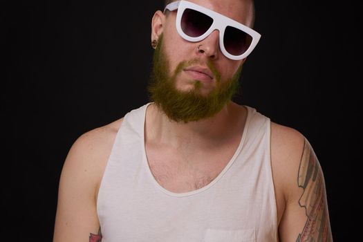 bearded macho man in white t-shirt sunglasses fashion tattoos. High quality photo