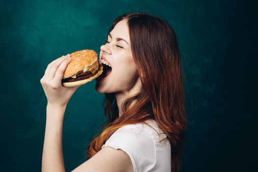 cheerful woman eating hamburger snack close-up lifestyle. High quality photo