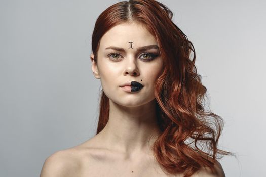 red-haired woman naked shoulders cosmetics horoscope close-up. High quality photo