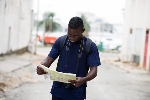 young tourist visiting the city and exploring it with a map and a camera