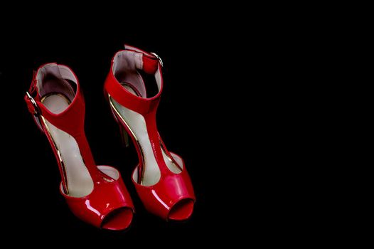 red patent leather sandal for the summer season on a black background