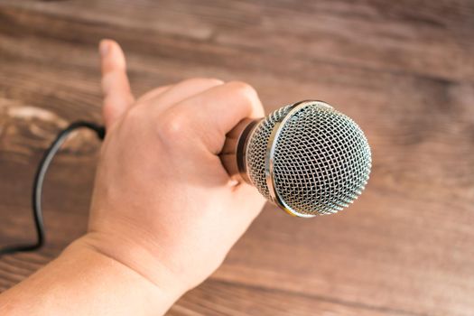 The singer holds in his hand a professional microphone for singing or recording sound