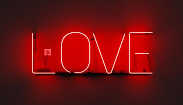 red neon sign with the word LOVE on wall and plugged-in cable. 3d illustration