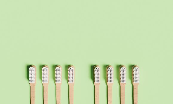 organic wooden toothbrushes on green background with space for text. 3d render