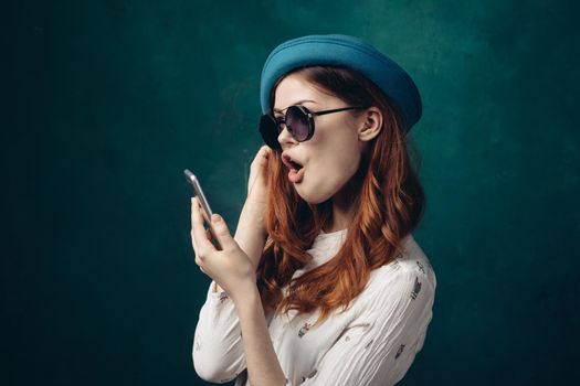 fashionable woman in blue hat with phone in hands communication technology. High quality photo