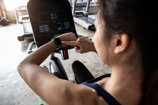 Young woman workout in gym healthy lifestyle, Woman is using smart watch during her workout with spinning or cyclo.