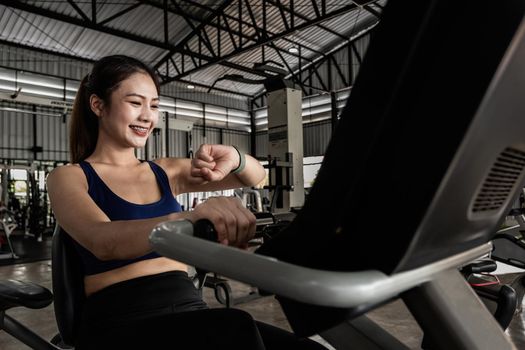 Young woman workout in gym healthy lifestyle, Woman is using smart watch during her workout with spinning or cyclo.