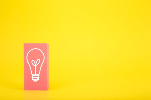 Concept of idea, creativity, start up or brainstorming. White drawn light bulb on pink rectangle against yellow background with copy space