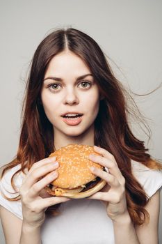 woman with a hamburger in her hands a snack fast food close-up. High quality photo