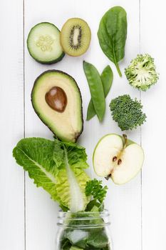 Glass jar mugs with green health vegetables lettuce leaves, lime, apple, kiwi, avocado, food concept.