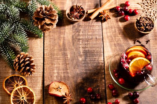 Christmas mulled wine with spices on a wooden rustic table.