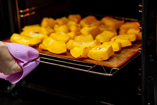 Pumpkin slices baked on a baking sheet in the oven. Homemade food, Vegan food, Healthy food, orange vegetables on a baking sheet and napkin, baked rustic vegetables, pop art, dessert during a diet