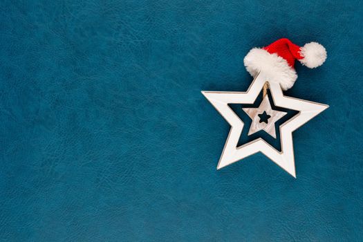 Christmas star with santa hat decoration. Christmas star on blue background.