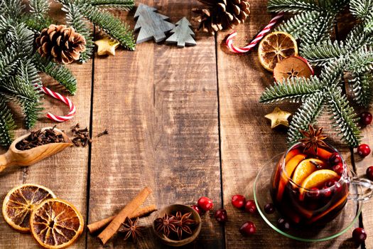 Christmas mulled wine with spices on a wooden rustic table.