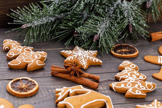 Tasty gingerbread cookies and Christmas decor on wooden background.