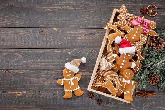 Tasty gingerbread cookies and Christmas decor on wooden background.