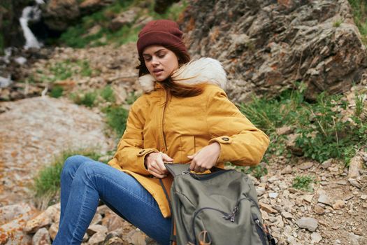 woman in yellow jacket hiking in the mountains travel adventure. High quality photo