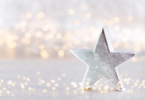 Christmas star, decor on bokeh silver background. Christmas or New Year minimal concept.