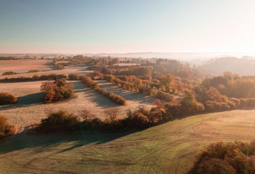 Aerial view of autumn sunrise countryside, traditional fall landscape with rising sun in Central europe. Foggy and misty sunrise. Frozen landscape from bird eye. Czech Republic,Vysocina highland