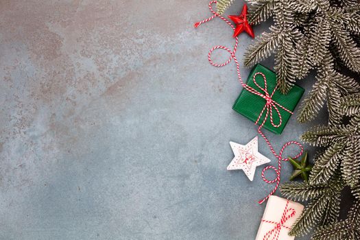 Christmas composition fir tree branches, star decor on blue background.