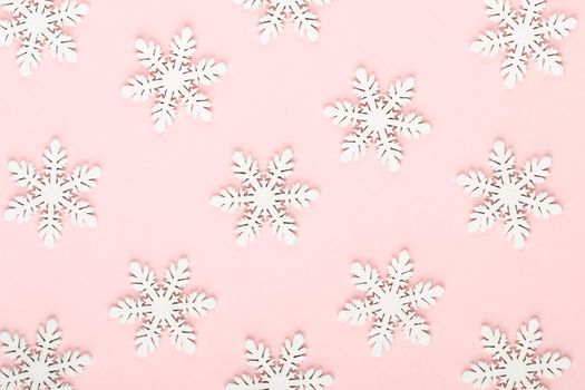 Christmas background. White snow decorations on a pink background.