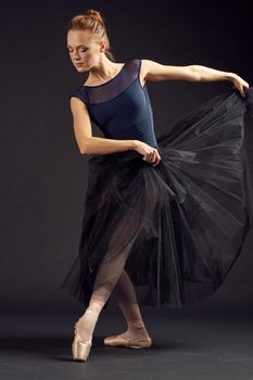 beautiful woman in a black dress dance fashion exercise dark background. High quality photo