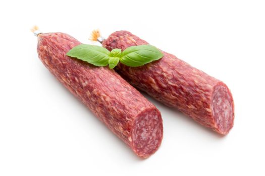 Salami smoked sausage, basil leaves and peppercorns isolated on white background.