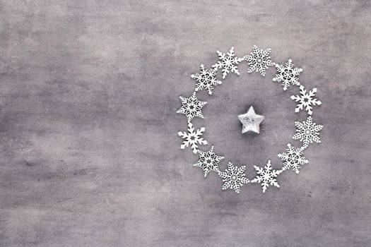 Christmas composition. White snow flakes wreath decorations on gray background. Christmas, winter, new year concept. Flat lay, top view, copy.