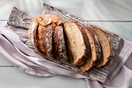 Sliced rye bread on cutting board, closeup.