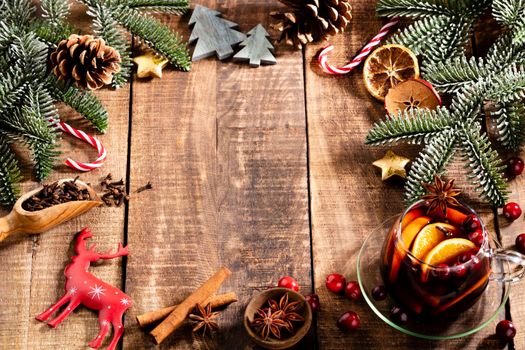 Christmas mulled wine with spices on a wooden rustic table.