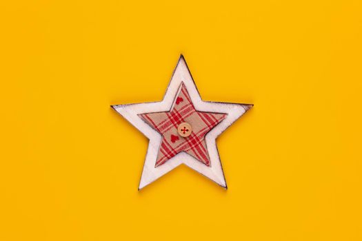 Christmas star decor on yellow colored background. 