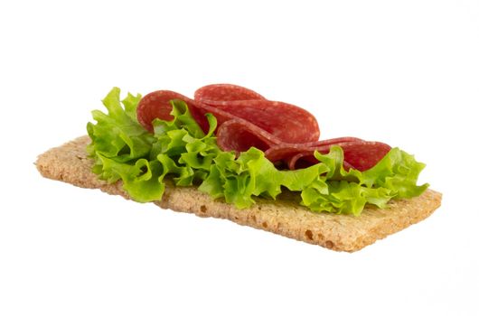 Variety of mini sandwiches with cream cheese, vegetables and salami. 