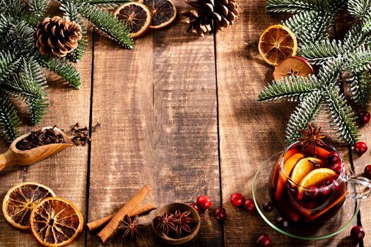 Christmas mulled wine with spices on a wooden rustic table.