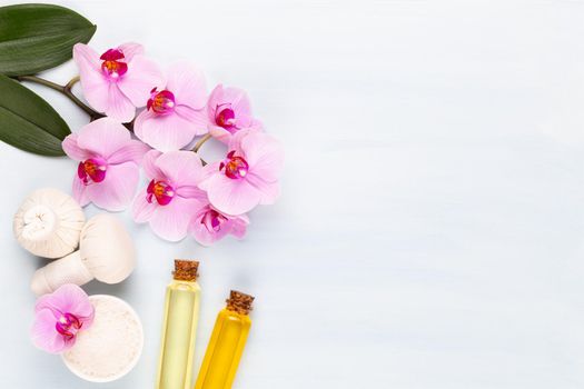 Spa aromatherapy background, flat lay of various beauty care products decorated with simple orchid flowers.