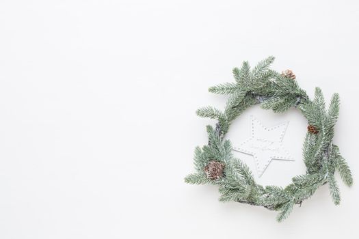 Christmas greeting card. Wreath decoration on white wooden background. New Year concept. Copy space.  Flat lay. Top view.