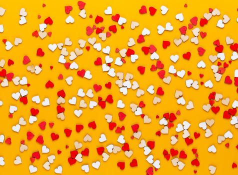 Small wooden hearts on a yellow background. A creative idea. Valentine day greeting card.
