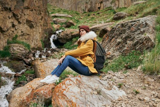 woman in yellow jacket hiking in the mountains travel adventure. High quality photo