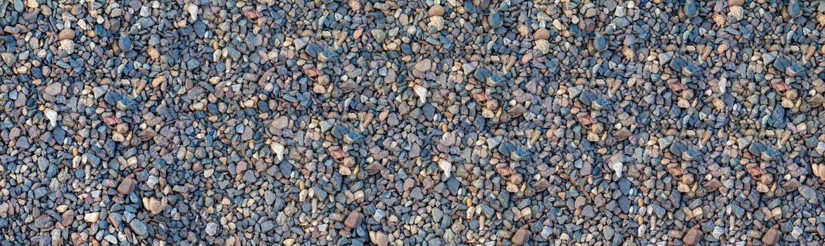 Crushed stone on the seashore. Selective focus on object. The stones were laid on the ground in the garden as a background. Background blur. Pebble stones background. banner