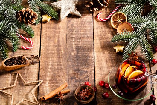 Christmas mulled wine with spices on a wooden rustic table.